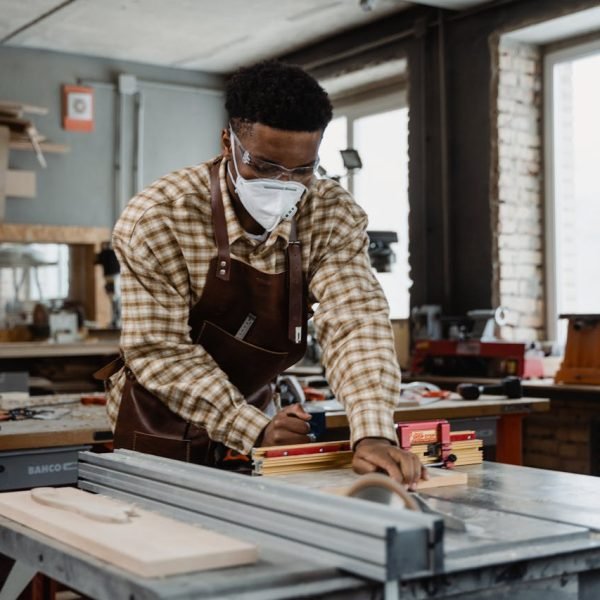 A focused craftsman demonstrating woodworking skills with tools in a workshop.