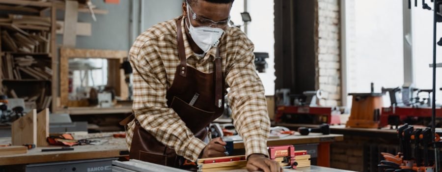 A focused craftsman demonstrating woodworking skills with tools in a workshop.